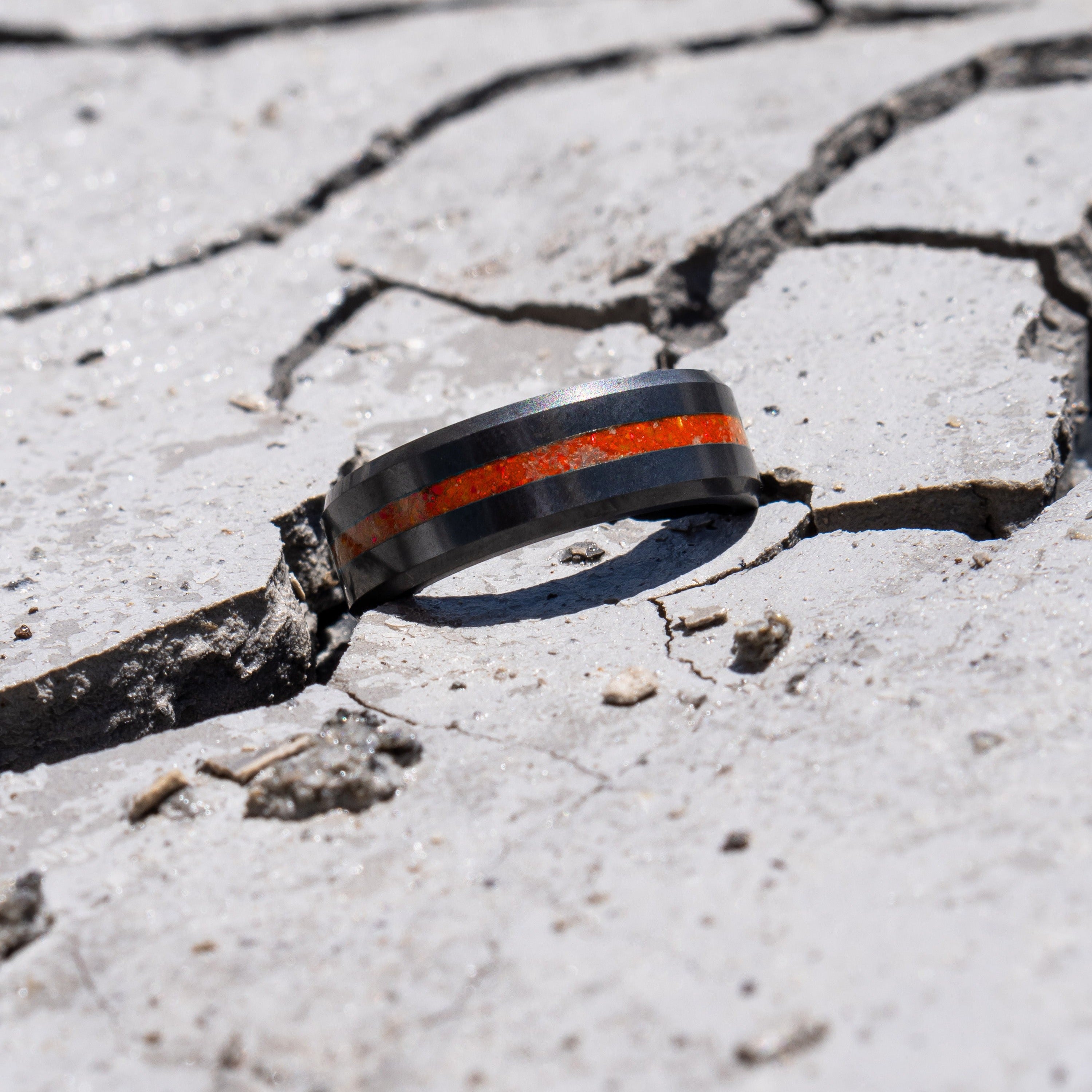 Ring shot #2 of our Elysium ARES Men's Black Diamond & Red Opal ring resting on a marble surface | ElysiumBlack.com | Men’s Opal Rings | Opal Rings for Men