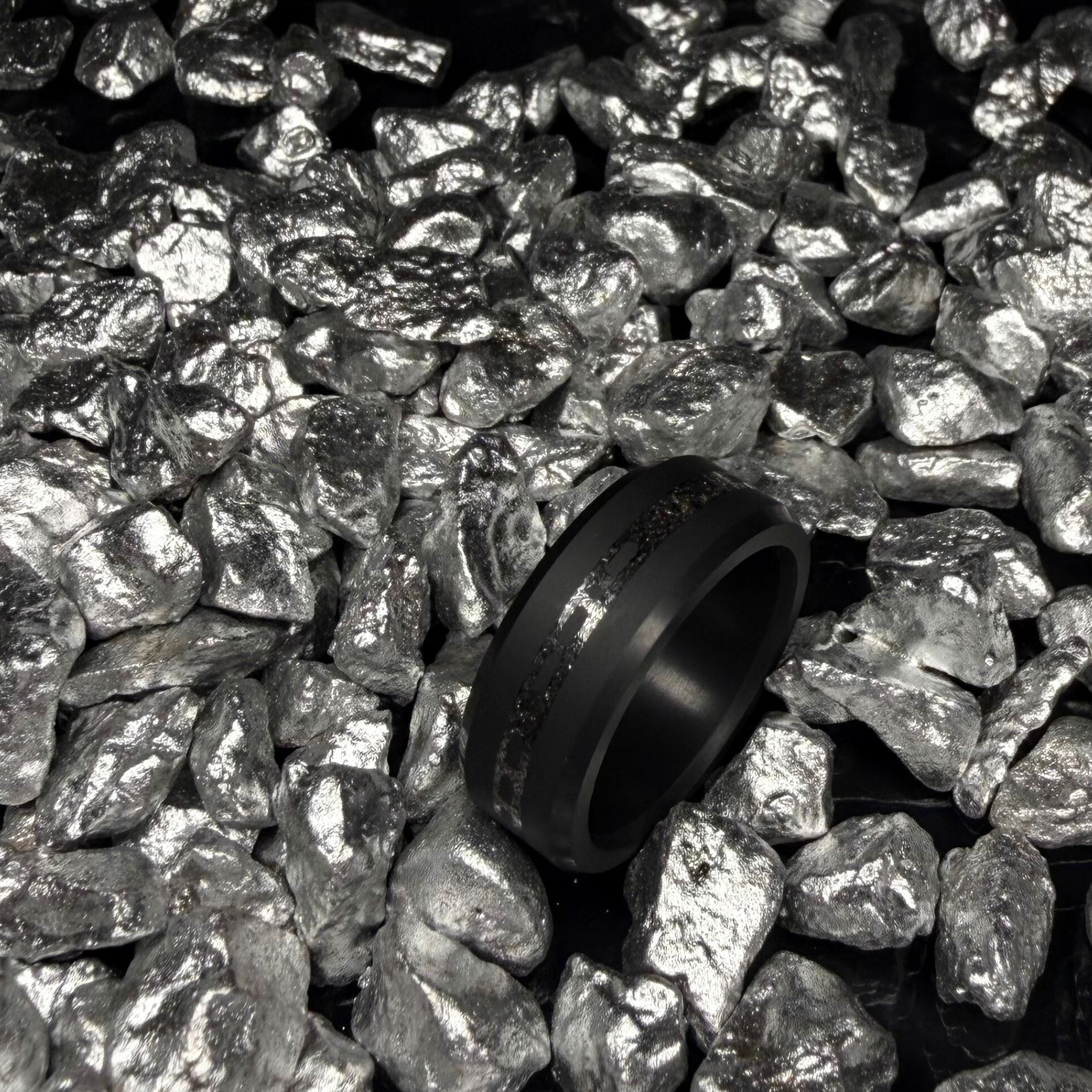 Solid Black Diamond ring with a laser engraved inlay reading "I love you" in morse code, filled with meteorite in a bed of silver rocks.