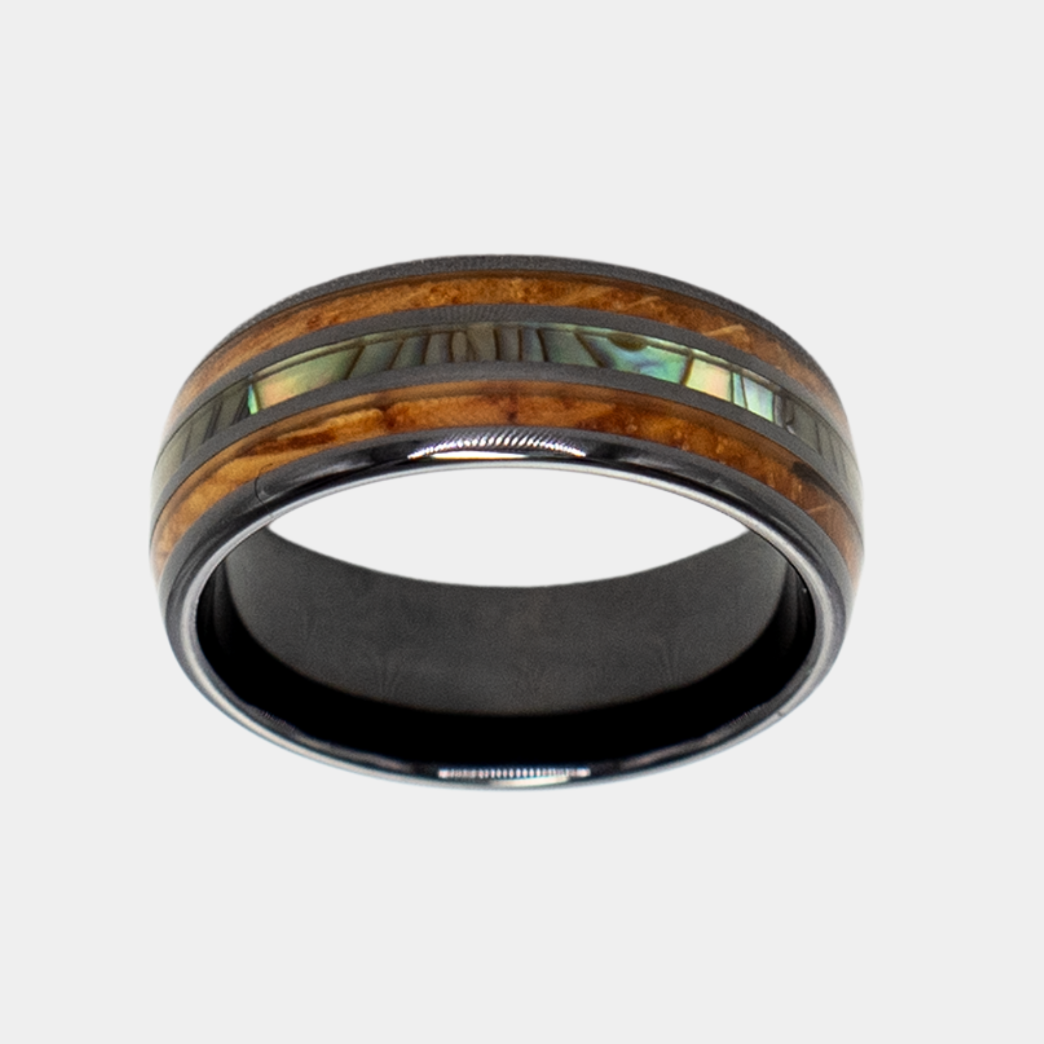 Odysseus ring – Polished Black Ceramic, Featuring a Double Whiskey Barrel Wood Inlay and Abalone Shell Inlay from the Hustler Collection. Top-down view showcasing ring face.