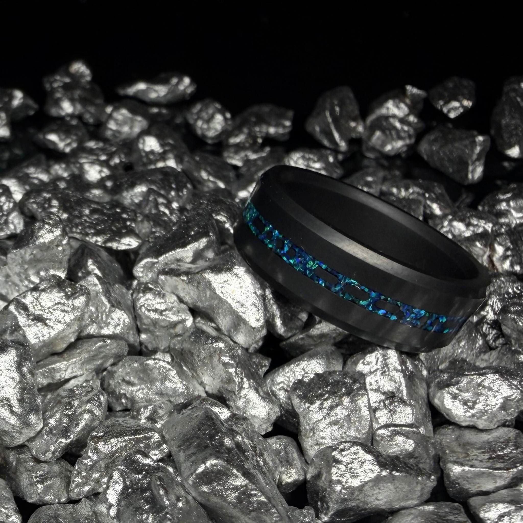 Solid Black Diamond ring with a laser engraved inlay reading "I love you" in morse code, filled with dark blue opal on a bed of rocks.