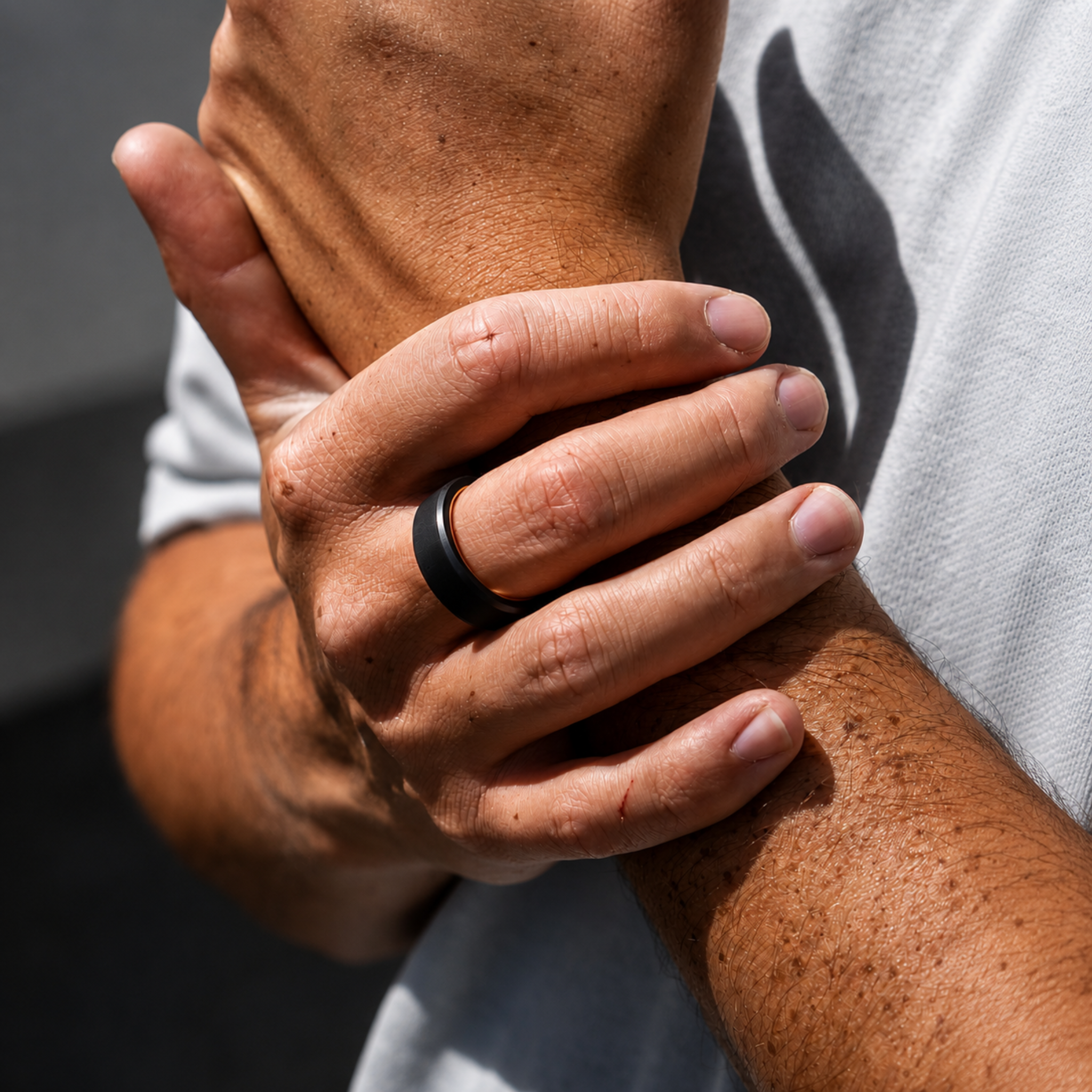 ARES 8mm solid black diamond wedding band with rose gold interior worn on hand in a lifestyle setting