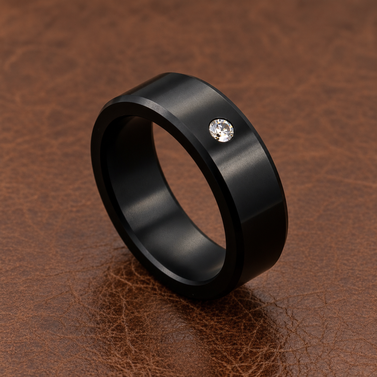Detail view of an 8mm ARES Stone Accent solid black diamond ring with a White diamond, standing upright on a brown textured surface.